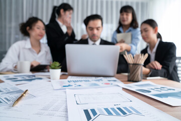 Focus financial data dashboard paper by business intelligence display graph, chart and statistic report on office table with blurred business people working in background. Habiliment