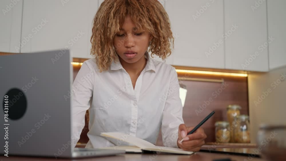Poster a woman is sitting in front of a laptop computer, typing and reading on the screen. she appears focu