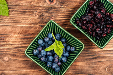 Fresh and dried berries on wooden table.