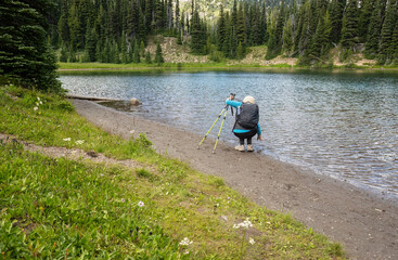 Woman checking water at Shadow Lake. Mount Rainier National Park. Washington State. - 784312048