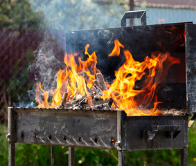 Firewood burns in a metal grill