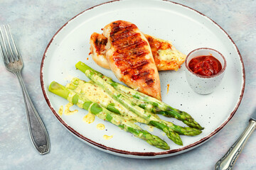 Chicken fillet cooked on a grill and garnish of asparagus. - 784313847