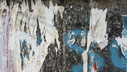 Weathered torn poster paper on urban wall
