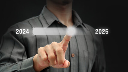 A businessman's hand touches the loading bar to count down from 2024 to 2025. Technology concept,...
