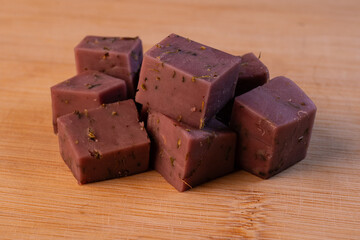 Lavender cheese, cut into cubes, lies on a cutting board.