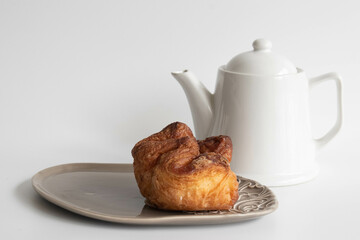 Tasty Puff with a cup of tea on white background