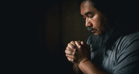 Person man, turned to God in prayer, demonstrating their religious faith and devotion through worship. Man hand in prayer, expressing his religious faith in God through worship of Jesus Christ.