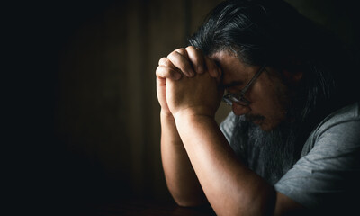 Man hand in prayer, expressing his religious faith in God through worship of Jesus Christ. Person man, turned to God in prayer, demonstrating their religious faith and devotion through worship.