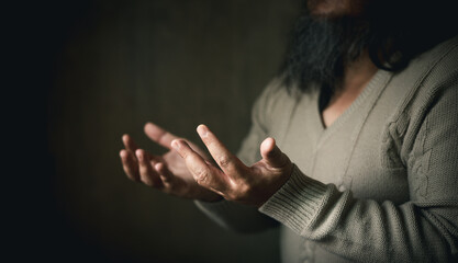 Man hand in prayer, expressing his religious faith in God through worship of Jesus Christ. Person...