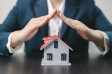 Home insurance concept. Homeowner entrusted the concept of protecting their property to the insurance agent's hand, ensuring their house and finances were secured through a mortgage insurance plan