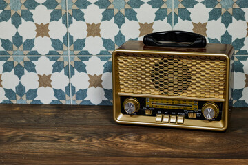 stylish retro radio player stands on a white wooden table. near tiles wall