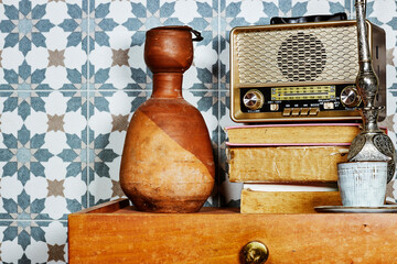 old retro vintage radio above books with clay bottle on wood table