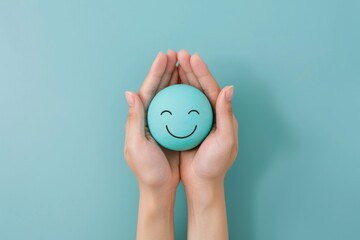 Image of gentle hands holding a light blue stress ball with a simplistic happy face, imbuing serenity and care