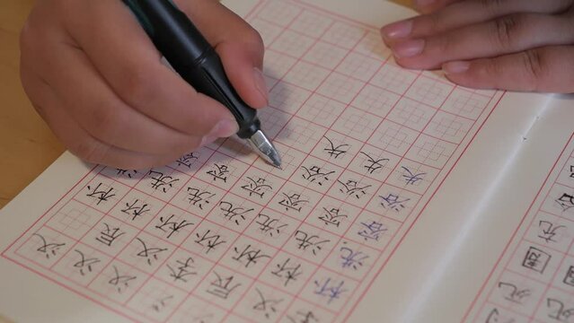 An Asian child is writing Chinese characters