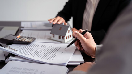 Businessman real estate seller explaining about property investment document with terms data of...