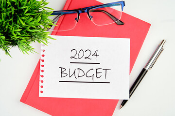 2024 Budget planning and allocation concept. text on a piece of paper on a red notebook on a white...