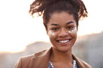 Outdoor portrait of happy joyful african american woman with shiny glitter on her face
