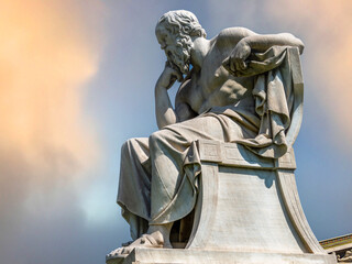 Sorates marble statue, the ancient Greek philosopher, under a fiery sky Travel to Athens, Greece. - 784342634