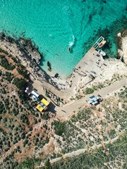 Obraz premium Vertical aerial top view of a bright blue lagoon in Malta
