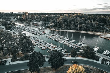 a marina with several boats sitting on the water and a car driving by