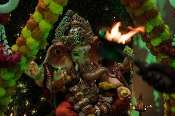 Person feasting at the colorful statue of Ganesha in the temple