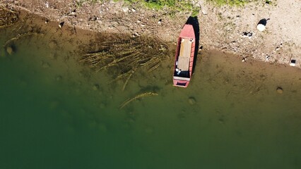 Top view of a wooden canoe docked on a shore