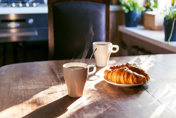 breakfast with cup of hot coffee and fresh croissants