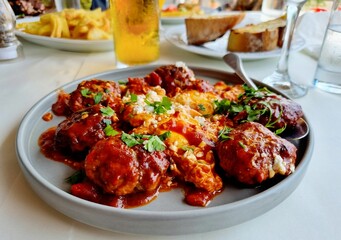 Closeup of delicious meatballs with tomato sauce on the table in a Greek restaurant