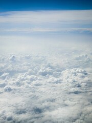 Naklejka premium Vertical shot of puffy white clouds in the sky from above
