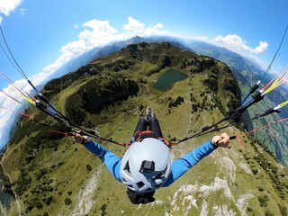 Top view of a skydiver paragliding on a scenic landscape with a parachute
