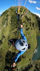 Vertical top view of a skydiver paragliding on a scenic landscape with a parachute