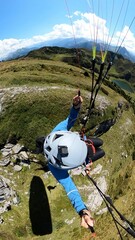 Vertical top view of a skydiver paragliding on a scenic landscape with a parachute