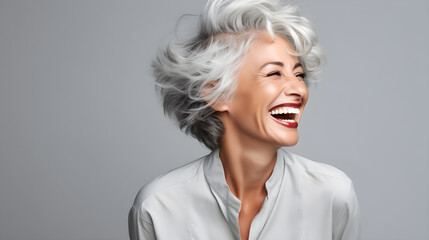 a woman with grey hair laughing with a big smile on her face - obrazy, fototapety, plakaty