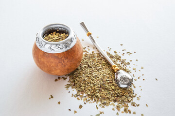 Mate tea in a typical South American calabash, with dried leaves next to it