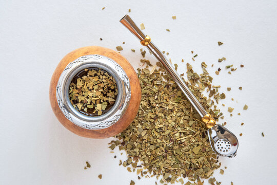 Mate tea in a typical South American calabash, with dried leaves next to it