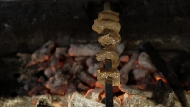 Chicken in skewer grilled over charcoal with smoke
