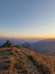 Obraz premium Beautiful view from a mountain peak with vast hills around it under the golden glow of the sunrise