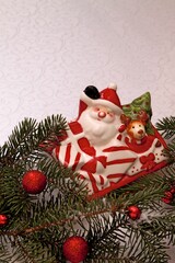 New Year's composition from a faience figurine of Santa Claus and fir branches.