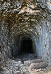 Vertical shot of a narrow mine tunnel in a stone cave