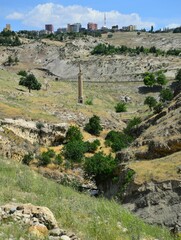 Fototapeta premium Vertical shot of an old stone tower with the city in the background, Turkey