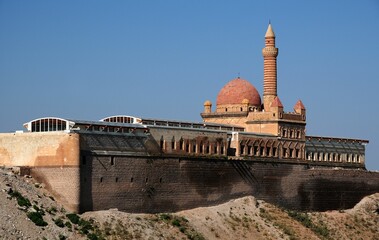 a large, brick and tan mosque with domes and arched windows