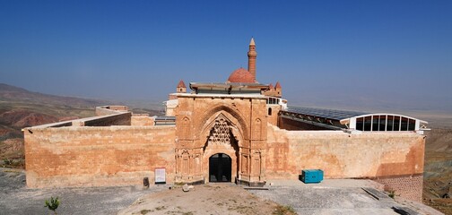 an old church built in front of a mountain range on top of a building