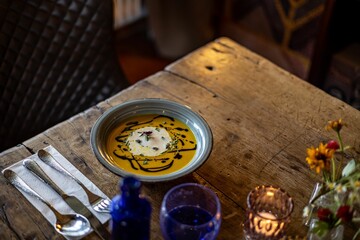 High angle shot of Pumpkin soup served in a bowl on a wooden table