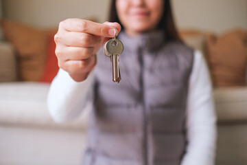 Closeup image of a woman holding and giving the keys for real estate concept