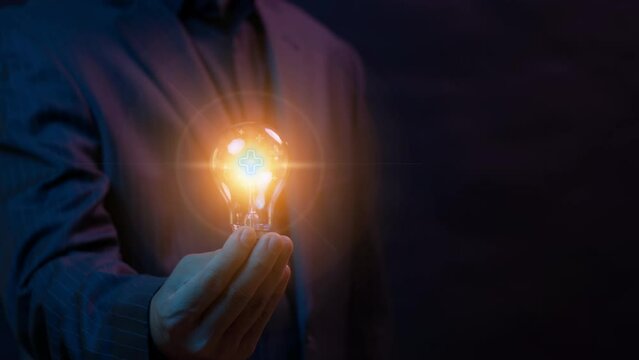 Positive thinking mindset concept. Idea, motivation, innovation, growth and inspiration. Personal development. Health care and insurance concept. Businessman showing glowing light bulb with plus signs