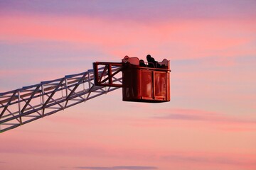 Beautiful shot of a red crane under the pink clouds in Barcelona
