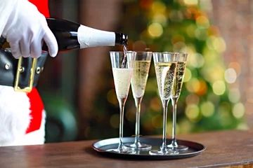 Foto op Plexiglas Santa Claus holding champagne glasses on the tray © Dasha Petrenko