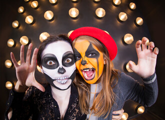Woman and girl with painted faces. Halloween theme