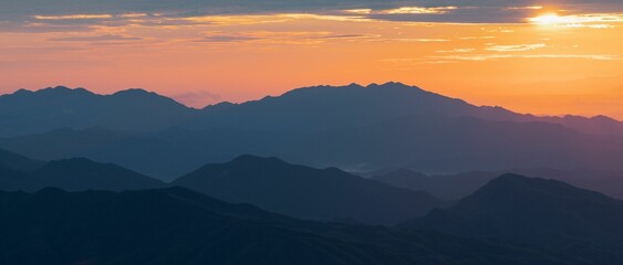 Beautiful view of a sunset over the silhouettes of the mountain range