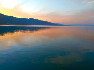 Breathtaking sunset behind the mountains over the sea